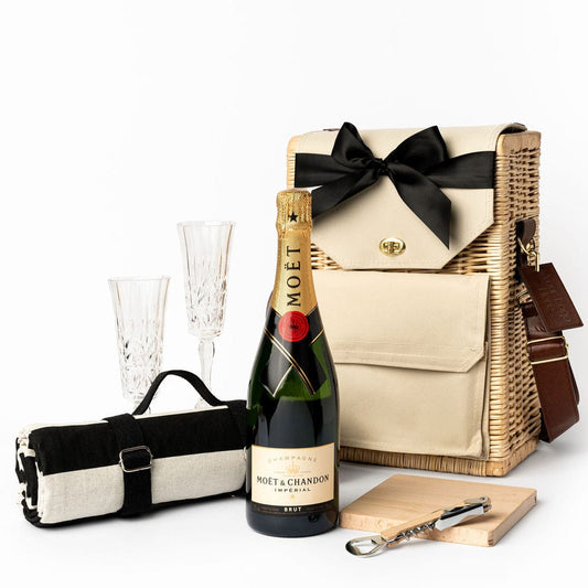 The Sunset To Remember Portable Wicker Picnic Basket with Acrylic Etched Champagne Glasses, Moet & Chandon Imperial Brut, Aquanord Water Resistant Picnic Rug, Beech wooden serving board and bottle opener. 