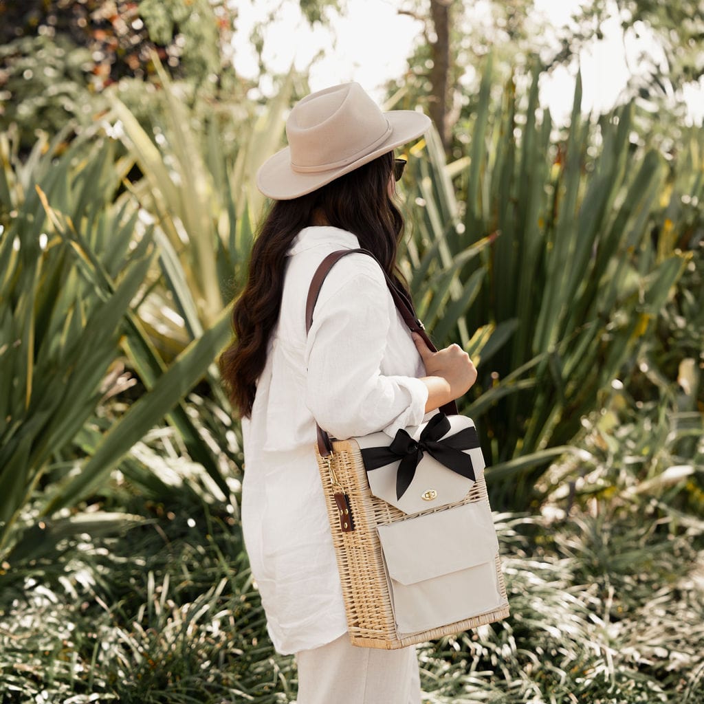 Woman carrying the Ellar Boutique Portable Wicker Picnic Basket outdoors. 