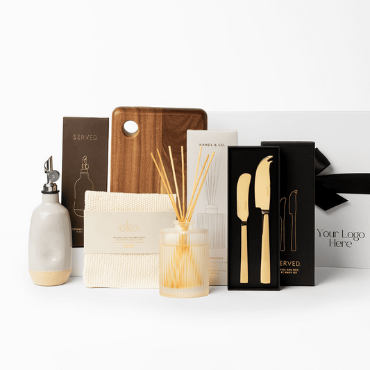 Elegant Abode Settlement Gift with ceramic oil pourer, acacia wooden board, cotton kitchen cloth, diffuser and cheese knives. 