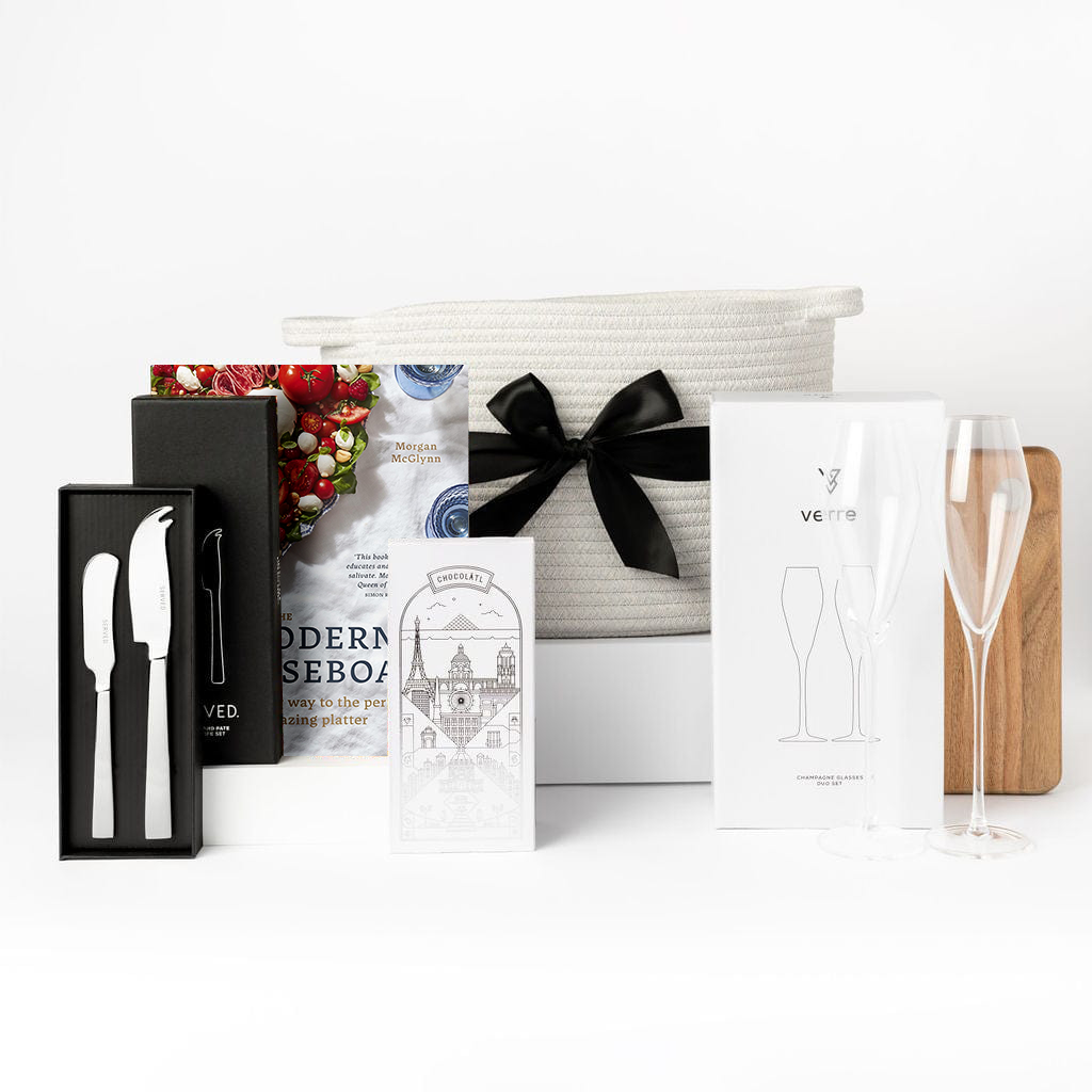 Ellar Boutique Settlement Gift with Champagne Flutes, chocolate, cheese knives, book, wooden board and cotton basket